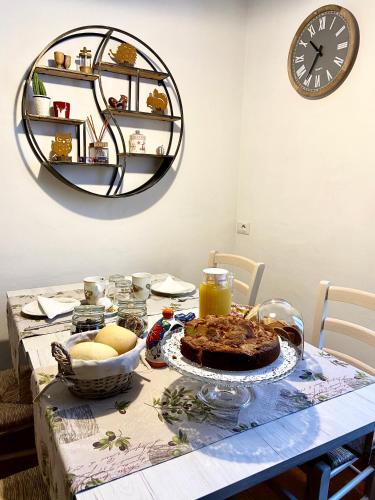a table with a cake and a clock on the wall at BoTép ai Tigli in San Pellegrino Terme
