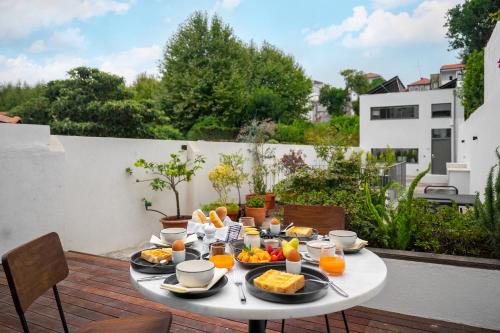 a table with plates of food on a balcony at Canto De Luz - Luxury Maison in Porto