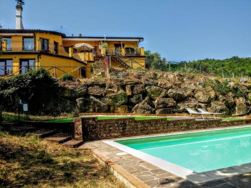 ein Haus und ein Pool mit einer Felswand in der Unterkunft Appartamento in Villa in Frassine