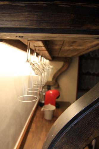 a row of wine glasses hanging from a wall at Book and Bed in Orvieto