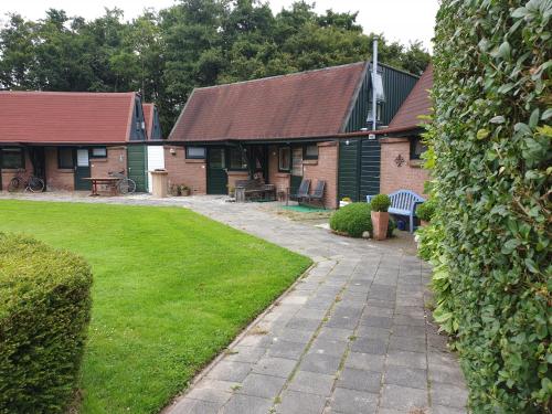 a house with a green yard with a walkway at Uniek vakantiehuisje in rustige en groene omgeving in Nieuwe-Niedorp