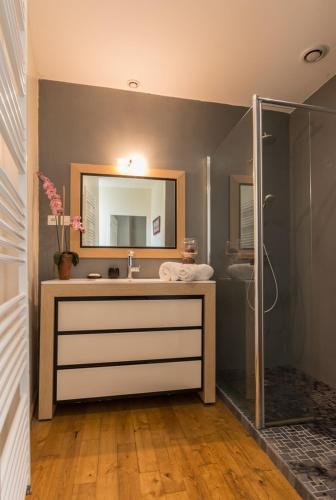 une salle de bain avec un lavabo, un miroir et une douche dans l'établissement La Baraka, à Léobard