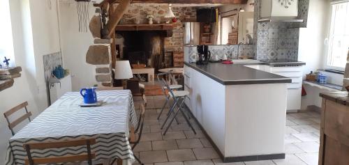 une cuisine avec une table et un comptoir avec une table et une table dans l'établissement Gîte les petits chemins, à Ledeuix