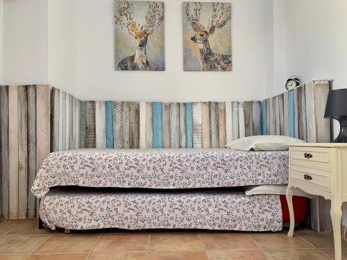 a bedroom with a bed with two pictures on the wall at Casa Marina in Frigiliana