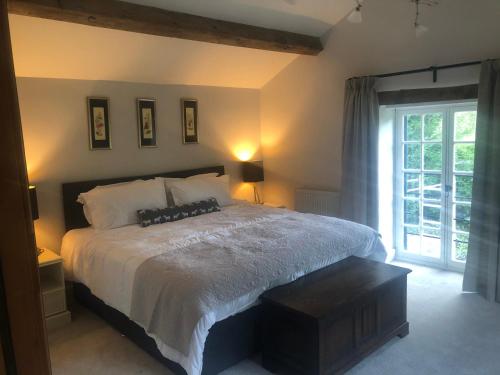 ein Schlafzimmer mit einem großen Bett und einem Fenster in der Unterkunft The Old Vicarage, Evenley. Brackley. in Brackley
