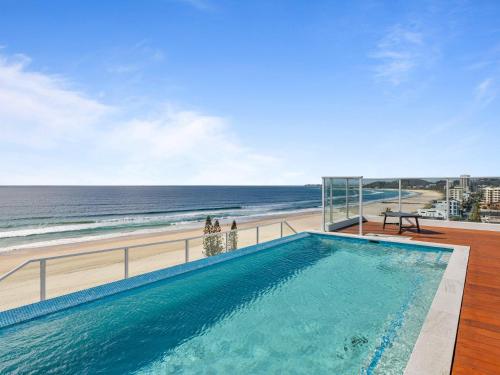 a swimming pool with a view of the beach at Ocean Views Apartment with Rooftop Pool - CoastHM in Gold Coast