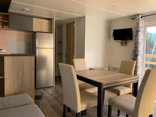 a kitchen and dining room with a table and chairs at Mobilhome 3 étoiles in Embrun
