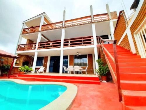 una casa con piscina frente a ella en Punta Mero House, en Tumbes