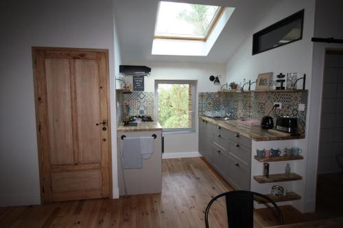 cocina con fregadero, ventana y puerta en Le studio de Jacobiel, en Verlhac-Tescou