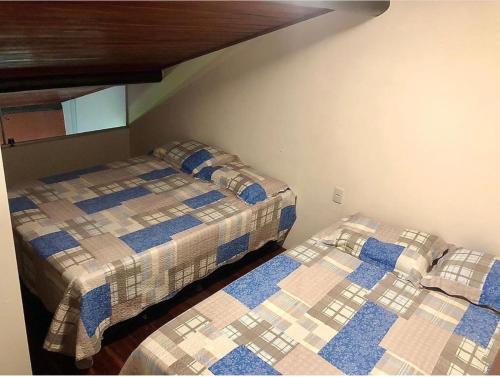 duas camas num pequeno quarto com em Gravata Apartamento Winterville em Gravatá