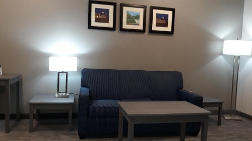 a living room with a blue couch and two lamps at Baymont by Wyndham Lafayette - Purdue University in Lafayette