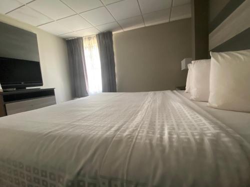 a large white bed in a hotel room at Baymont by Wyndham Lafayette - Purdue University in Lafayette