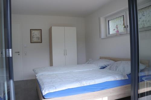 a bed in a bedroom with a glass door at Fewo Haus Edith in Lug