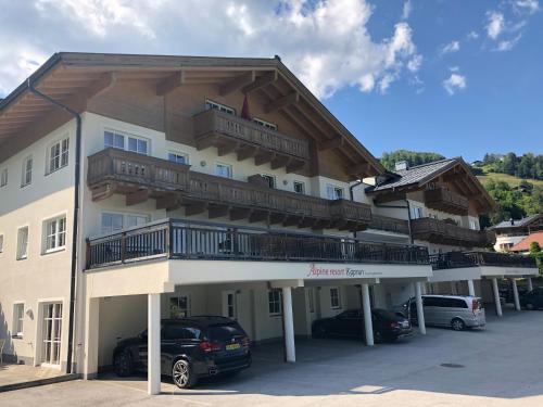 a large building with cars parked in a parking lot at AlpinResort Kaprun 11 in Kaprun
