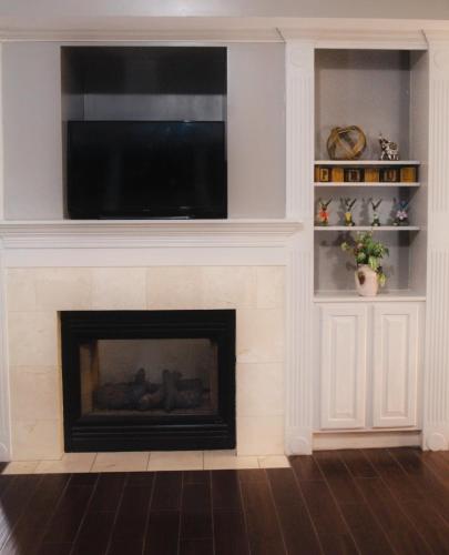 a living room with a fireplace with a flat screen tv at Baymont by Wyndham Lafayette - Purdue University in Lafayette