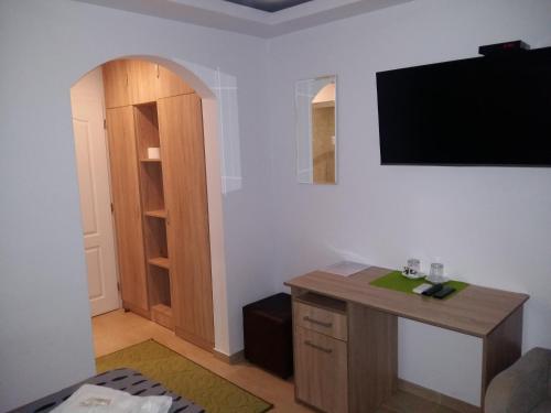a room with a desk and a television on the wall at Guest House Harmony in Veliko Tŭrnovo