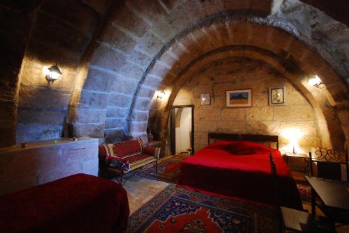 a bedroom with a red bed and a stone wall at Karamanli Konagi in Guzelyurt