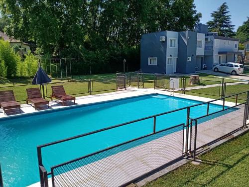 a swimming pool with a fence around it at Maliva Cabanas in La Falda