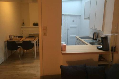 a kitchen with a counter and a table with chairs at Cosy little house in Bruges