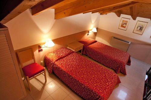 a room with two beds and a chair at Santanna in Verbania