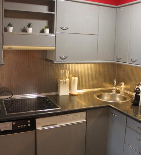 a kitchen with white cabinets and a sink at SENTIR VIC in Vic
