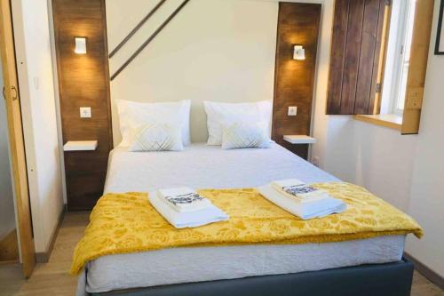um quarto com uma cama grande com duas toalhas em My Historic House 2 em Brangança