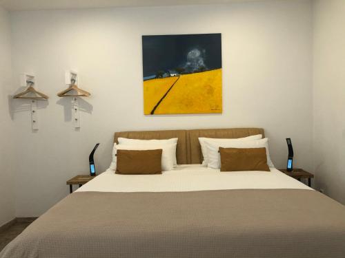 ケルステルバッハにあるエクスクルーシブ エアポート アパートメントのベッドルーム1室(ベッド1台付)が備わります。壁には絵画が飾られています。
