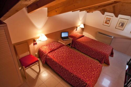 a room with two beds and a laptop on a table at Santanna in Verbania