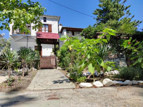 a house with a gate in front of a garden at Flower house in Chorefto