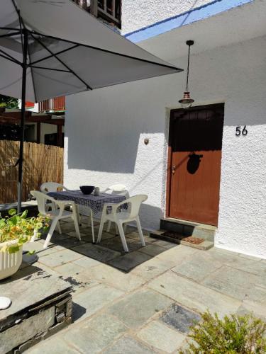 a patio with a table and chairs and an umbrella at Flower house in Chorefto