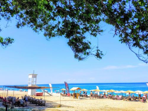 a beach with chairs and umbrellas and a lighthouse at Flower house in Chorefto