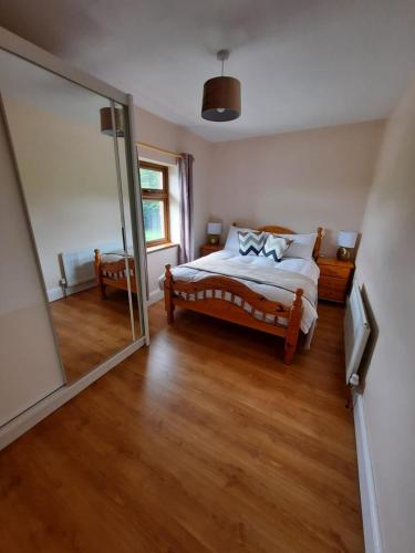 ein Schlafzimmer mit einem Bett und einem großen Spiegel in der Unterkunft Lovely ballina townhouse in Ballina