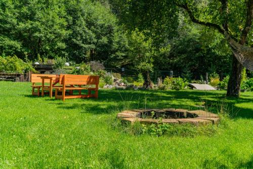 a park with a bench and a fire pit in the grass at Farma Zelená Ruža in Kľačno