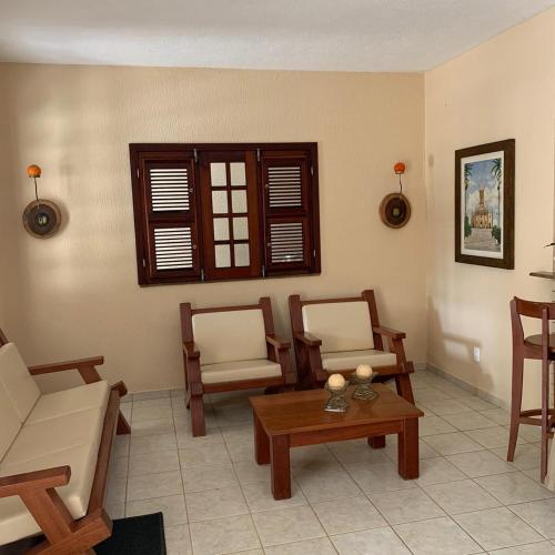 a living room with two chairs and a table at Ótima Casa em Guaramiranga in Guaramiranga