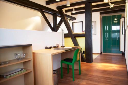 a kitchen with a desk and a green chair at Suite „Niedersachsen“ - wunderschönes Apartment in Fachwerkhaus in Hannover