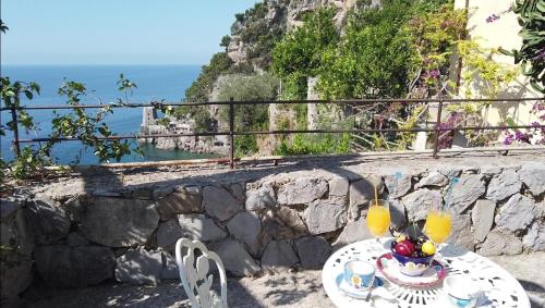 a table with a plate of food on top of a stone wall at Hotel Dimora Fornillo in Positano