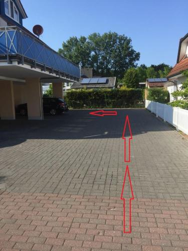 a parking lot with a red arrow pointing to a house at Am Horizont No 1 für 2-4 Pers, 2 Schlafz, Babybett, Südbalkon, kostenloser Parkplatz, 500 Meter zum Strand in Zingst