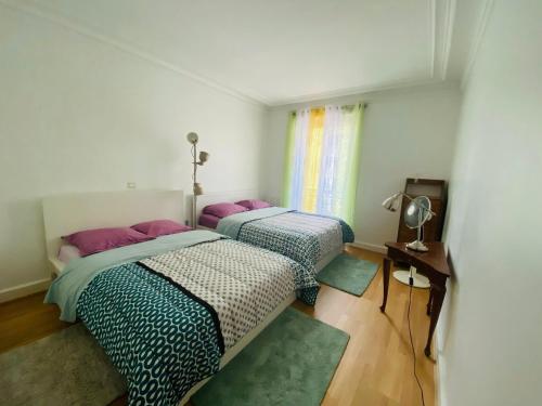 2 camas en una habitación pequeña con ventana en Champs Elysées, en París