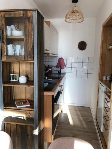 - une cuisine avec des placards en bois et un comptoir dans l'établissement Zu Hause am See - Pool, Sauna, Fitnessraum, à Schluchsee