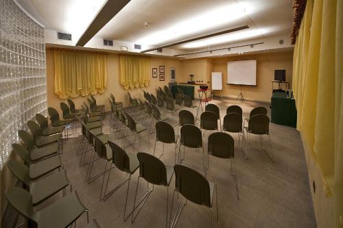a lecture hall with chairs and a podium and a screen at Santanna in Verbania