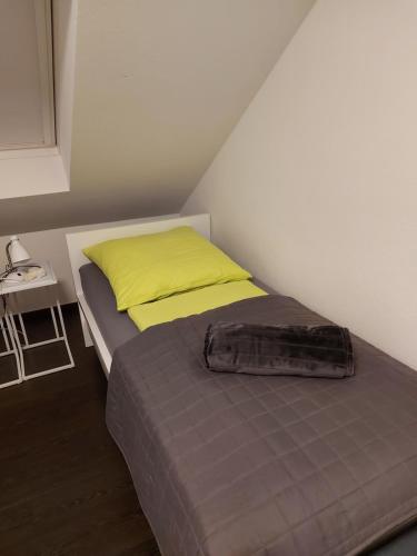 a small bedroom with a bed with a yellow pillow at Haus Rodriguez in Baesweiler