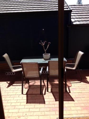 a table and chairs with a potted plant on a patio at Salt Air on Banyan in Warrnambool