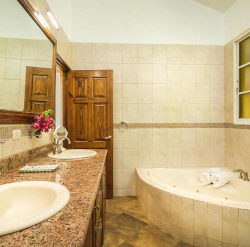 baño con 2 lavabos y bañera grande en The Amazing Hispaniola Villa 145 en Sosúa