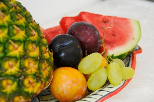 a plate of fruit with a pineapple and a slice of watermelon at Hotel Dimora Fornillo in Positano