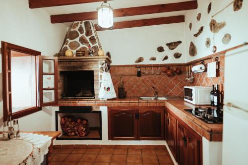 Villa Los Hinojales في لوس سيلوس: مطبخ مع موقد ومدفأة