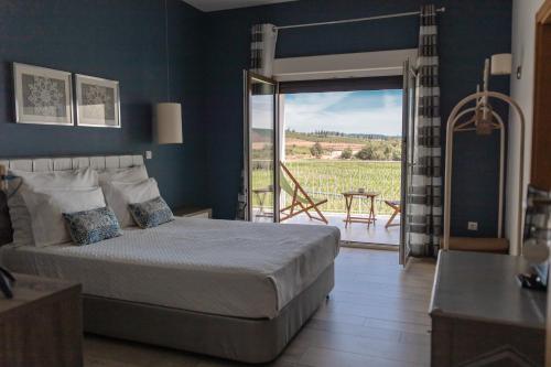 a bedroom with a bed and a door to a patio at Quinta Ponte da Capinha in Capinha