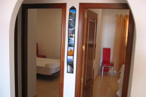 einen Flur mit einem Zimmer mit einem Bett und einem Spiegel in der Unterkunft Casa Rosita in Agaete
