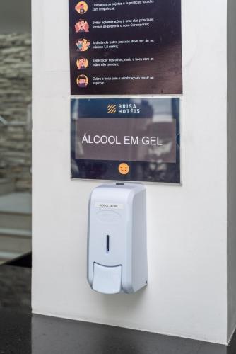 a white electrical outlet on a wall with a sign at Hotel Brisa Praia Pajuçara in Maceió