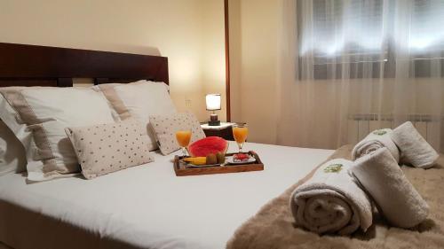 a bedroom with a bed with towels and two glasses of orange juice at Residencial Caliza in Madrid