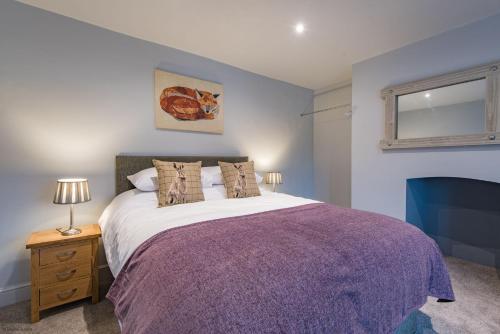 - une chambre avec un grand lit et une couverture violette dans l'établissement Customs House by Bloom Stays, à Faversham